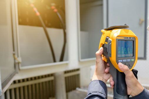 Electrical craft person using IR instrument to look for potential damage.
